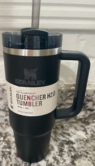 Black Stanley Quencher H2O tumbler with handle on a marble surface.
