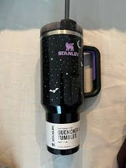 Black tumbler with a design on a white surface