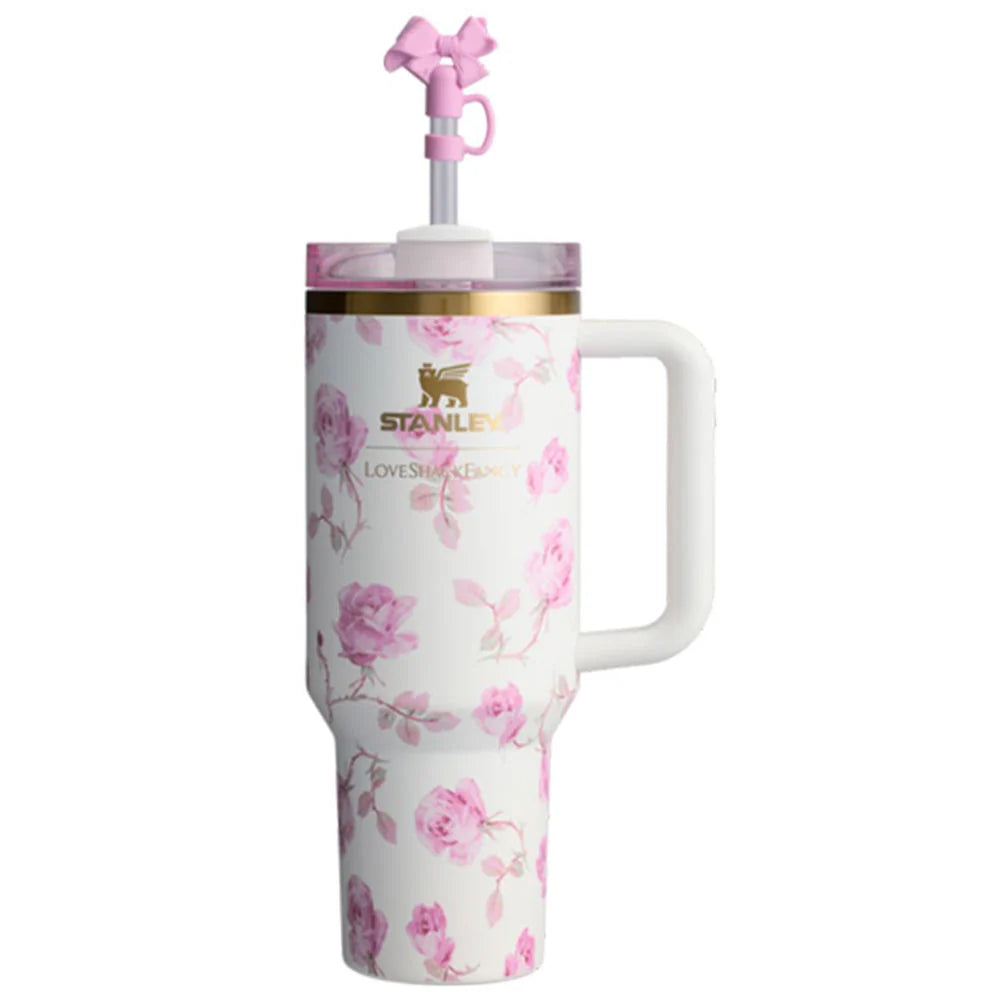 Floral-patterned tumbler with a handle and pink straw on a white background