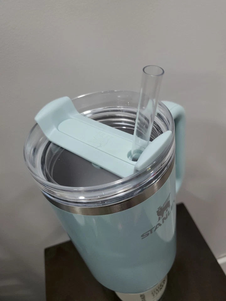 Light blue tumbler with a straw and clip on a neutral background