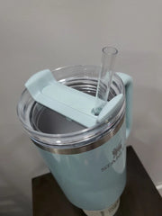 Light blue tumbler with a straw and clip on a neutral background