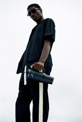 Person holding a black cylindrical object against a white background