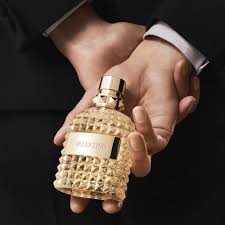 Person holding a gold bottle with a dark background