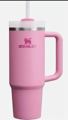 Pink Stanley mug with handle and straw on a white background