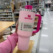 Pink Stanley tumbler held by a person in a store setting