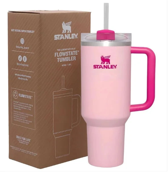 Pink Stanley tumbler with handle and straw next to its packaging box.