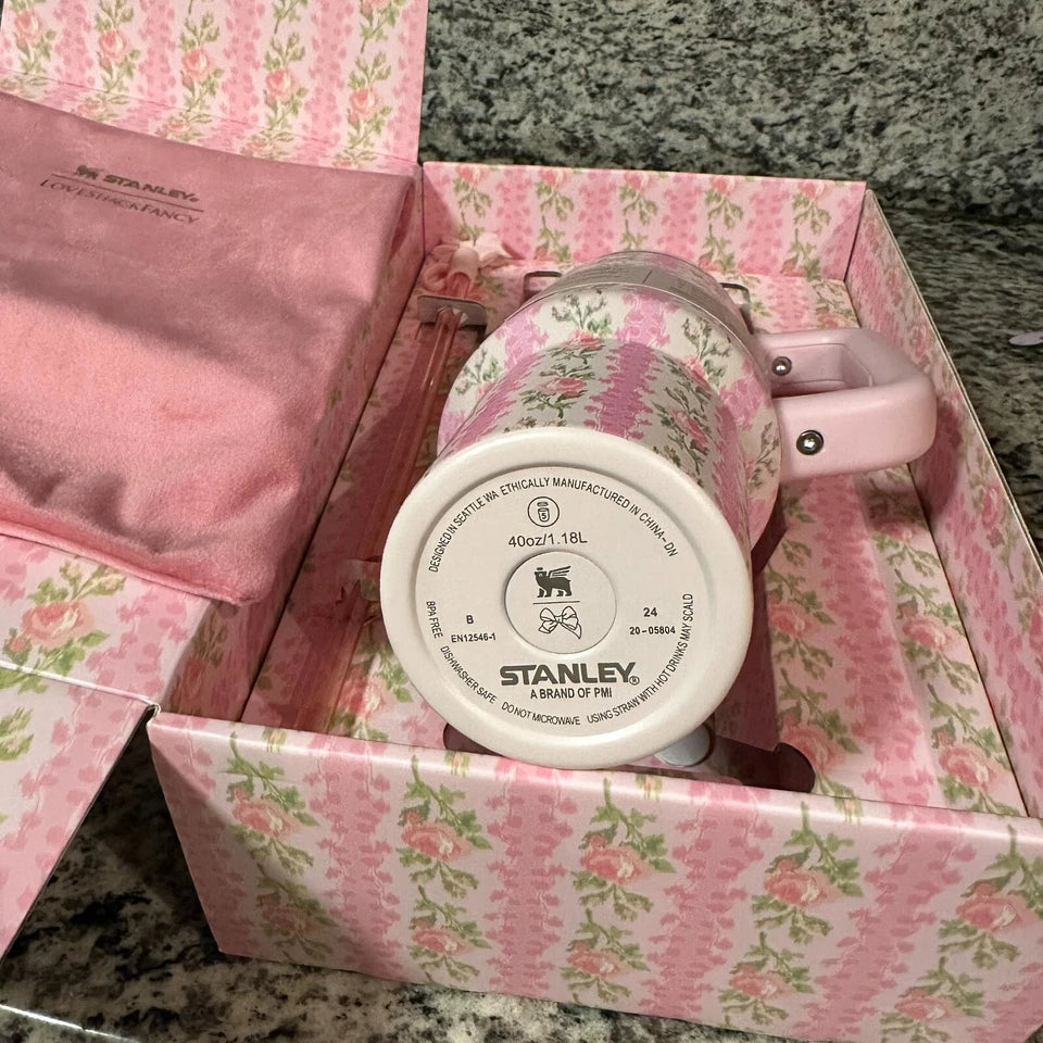 Pink floral-patterned Stanley mug in a matching pink box on a marble surface