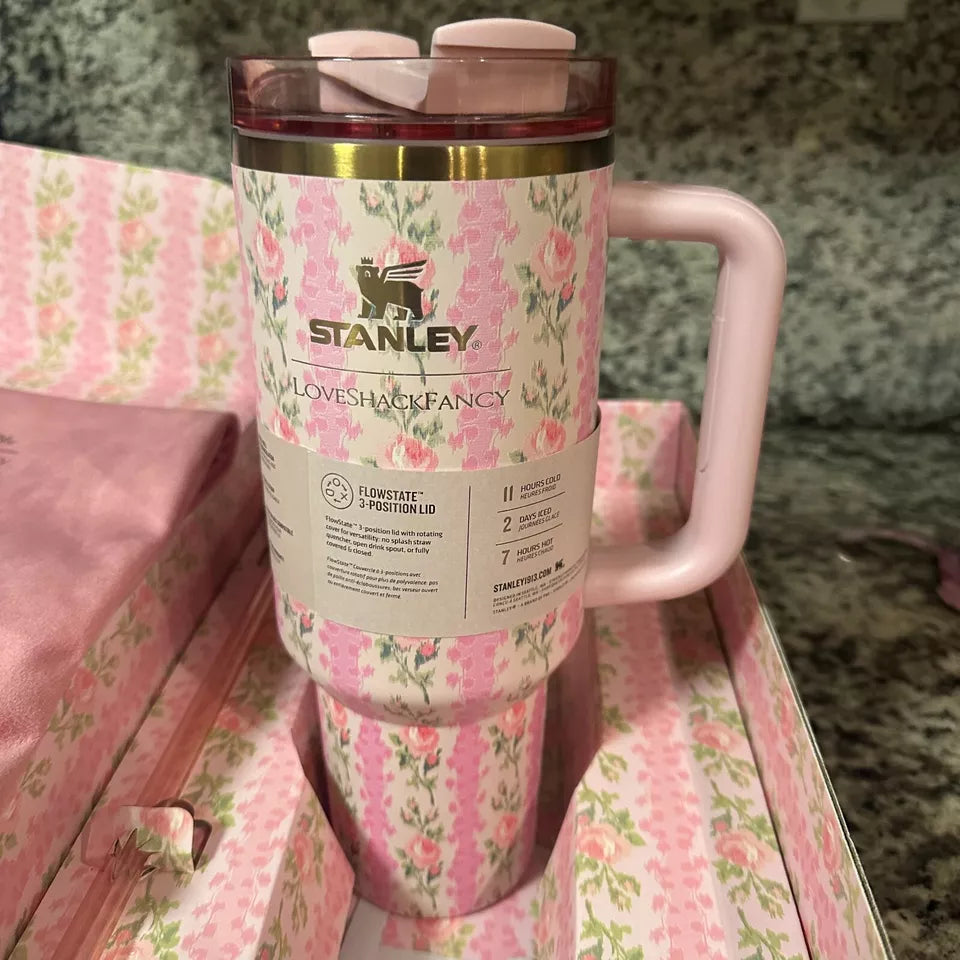 Pink floral Stanley mug on a matching pink surface with a textured background