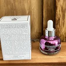 Purple bottle with dropper on a wooden shelf next to a white box