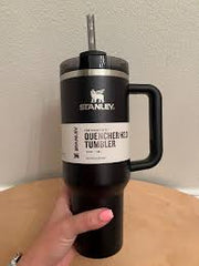 Stanley tumbler with straw on a wooden surface