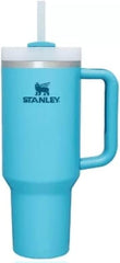 Turquoise Stanley tumbler with handle and straw lid on a white background