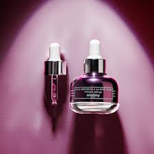 Two skincare bottles with droppers on a gradient purple background