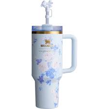 White tumbler with floral design and handle on a white background