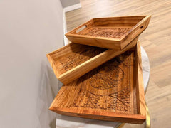 Wooden tray set with intricate carvings on a light wooden floor.