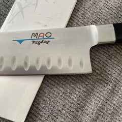 Hand holding a small, smooth stone against a white background